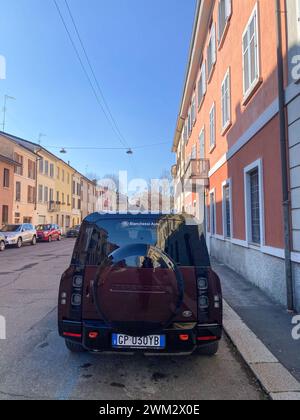 Cremona, Italia - 15 febbraio 2024 Land Rover Defender 130 se Sedona Red suv 4x4 in posizione di parcheggio. Foto Stock