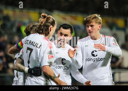 Kiel, Germania. 23 febbraio 2024. Calcio: Bundesliga 2, Holstein Kiel - FC St. Pauli, Matchday 23, Holstein Stadium. St I giocatori di Pauli tifanno il tifo dopo il gol per 4:1. Credito: Frank Molter/dpa - NOTA IMPORTANTE: in conformità con i regolamenti della DFL German Football League e della DFB German Football Association, è vietato utilizzare o far utilizzare fotografie scattate nello stadio e/o della partita sotto forma di immagini sequenziali e/o serie di foto video./dpa/Alamy Live News Foto Stock