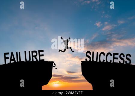 L'uomo salta attraverso il testo che non riesce a raggiungere il successo sopra la scogliera del tramonto concetto di sfondo per avere successo nel lavoro e nell'azienda. Foto Stock