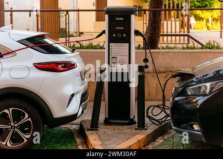 Ricarica di auto elettriche presso un caricabatterie pubblico per auto elettriche. Mérida, Badajoz, Estremadura, Spagna, Europa Foto Stock