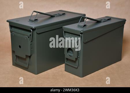 Scatole di metallo verdi per munizioni militari con coperchio chiuso. Isolato su sfondo di carta artigianale. Foto Stock