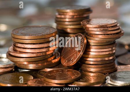 Tre pile di piccoli cambiamenti principalmente in due pence e un pence in cima ad altri piccoli cambiamenti nella valuta della sterlina Foto Stock