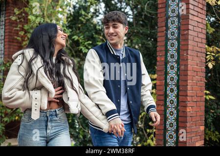 giovani coppie multirazziali che camminano insieme innamorati durante la loro prima passeggiata nel parco all'aperto Foto Stock