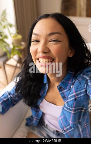 La giovane donna birazziale sorride brillantemente Foto Stock