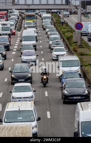 Moto che viaggia tra due linee di auto sul Boulevard Peripherique di Parigi. La circolazione interlinea dei motocicli è in fase di sperimentazione in Francia Foto Stock