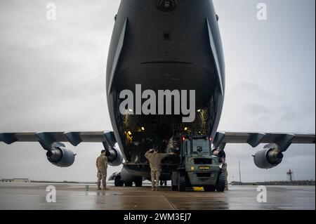 Gli aviatori statunitensi assegnati al 48th Logistics Readiness Squadron caricano il carico su un C-17 Globemaster III durante l'implementazione del progetto Kinetic Cargo presso RAF Lakenheath, Inghilterra, 22 febbraio 2024. Project Kinetic Cargo garantisce la consegna tempestiva di forniture e attrezzature essenziali in varie sale operative, consentendo la preparazione e l'efficacia della missione. (Foto U.S. Air Force di Airman 1st Class Seleena Muhammad-Ali) Foto Stock