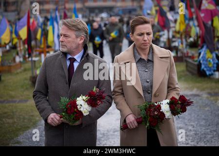 Leopoli, Ucraina. 23 febbraio 2024. Il primo ministro danese mette Frederiksen, a destra, e il marito Bo Tengberg, a sinistra, rendono omaggio ai soldati caduti sul campo di Marte all'interno del cimitero di Lychakiv, 23 febbraio 2024 a Leopoli, Ucraina. Credito: Pool Photo/Ufficio Stampa Presidenziale ucraino/Alamy Live News Foto Stock