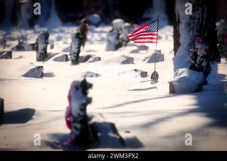 Bandiere americane in un cimitero con nevicate fresche in un cimitero del Wisconsin settentrionale. Foto Stock