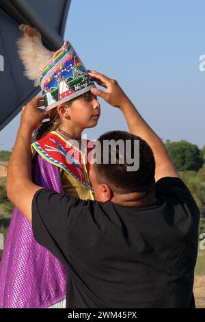 Padre nativo americano che regola il copricapo decorativo di sua figlia Foto Stock