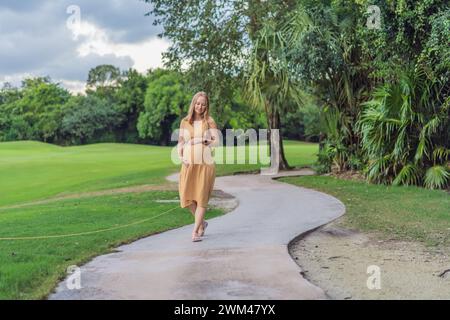Una scena tranquilla in cui una donna incinta gode di momenti di pace nel parco, abbracciando la serenità della natura e trovando conforto durante la gravidanza Foto Stock