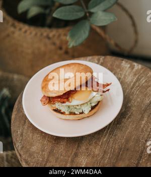 Un succoso cheeseburger con panini di semi di sesamo su un piatto con motivi rossi Foto Stock