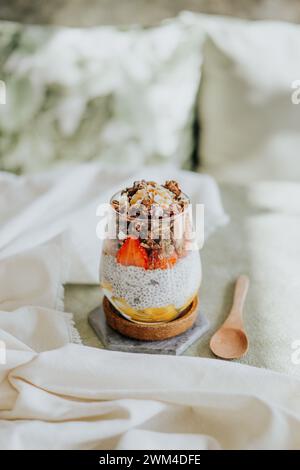 Primo piano di un dessert a strati in un bicchiere, con budino con fragole e muesli Foto Stock