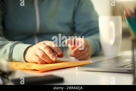 Maschio lato tenendo la penna in argento. Riempire in indirizzo sulla busta gialla di corrispondenza per applicazione Concetto di assunzione Foto Stock