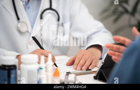 Primo piano di un paziente e di un medico di sesso maschile consultati in un ospedale Foto Stock