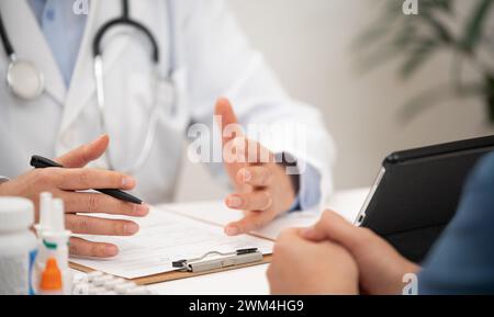 Primo piano di un paziente e di un medico di sesso maschile consultati in un ospedale Foto Stock