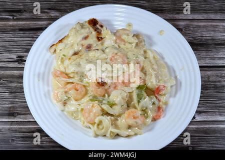 Cremoso mix di gamberi al forno, calamari di calamari, filetto di pesce, mozzarella, fette di peperone colorate e salsa bianca di farina, latte e gh Foto Stock