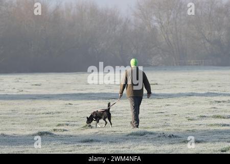 Dorney, Buckinghamshire, Regno Unito. 24 febbraio 2024. Un uomo cammina il suo cane su Dorney Common. E' stato un inizio freddo e gelido stamattina a Dorney, nel Buckinghamshire, con temperature a meno 3 gradi. Crediti: Maureen McLean/Alamy Live News Foto Stock