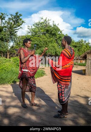 Due giovani guerrieri Maasai guardano una videocamera GoPro a Mikumi, Tanzania Foto Stock