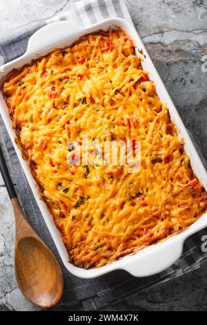 La casseruola di pollo King Ranch combina pollo succoso, peperoni colorati e tortillas in una salsa di formaggio frizzante e cremosa in un piatto da forno su un marmo Foto Stock