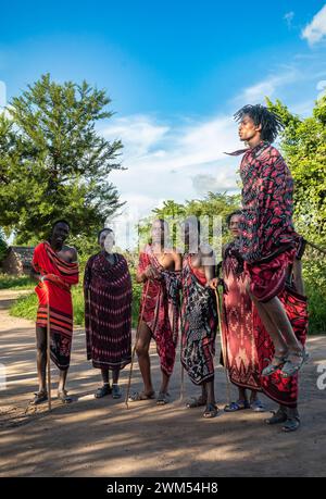 Un gruppo di guerrieri Maasai esegue la danza tradizionale del salto nel loro villaggio di Mikumi, Tanzania Foto Stock