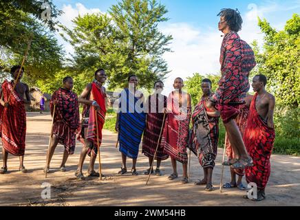 Un gruppo di guerrieri Maasai esegue la danza tradizionale del salto nel loro villaggio di Mikumi, Tanzania Foto Stock
