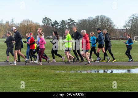 Persone che prendono parte a Rushmoor Parkrun, un evento regolare di sabato ad Aldershot, Hampshire, Inghilterra, Regno Unito, nel febbraio 2024 Foto Stock