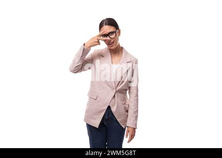 giovane donna bruna europea snella e perplessa si erge con cura su uno sfondo bianco Foto Stock