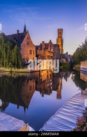 Dal molo Rosary di Bruges. Belfry della città vecchia e delle storiche case delle corporazioni e delle case dei mercanti in un'atmosfera serale. riflessi d'acqua Foto Stock