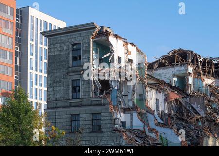 Vecchio edificio crollato sullo sfondo di nuovi edifici a più piani Foto Stock