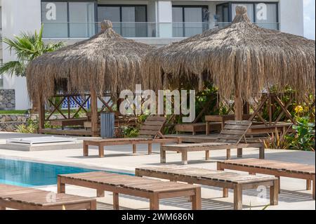 bungalow e sedie a sdraio vicino alla piscina e al caffè a Cipro Foto Stock