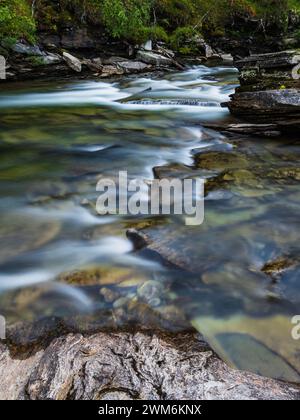 Il tranquillo fiume Ljusnan si snoda attraverso l'aspro paesaggio di Härjedalen, con le sue acque che cadono su rocce e ciottoli. La luce soffusa e delicata Foto Stock