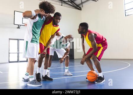 Gruppo di uomini afroamericani che giocano a basket al chiuso Foto Stock