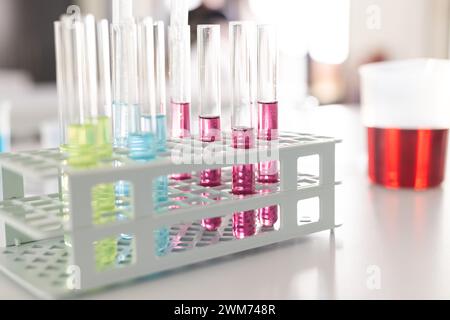 Provette per analisi con liquidi colorati in un rack da laboratorio, focalizzate sul primo piano Foto Stock