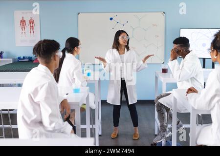 Una giovane donna birazziale insegna in un laboratorio delle superiori Foto Stock