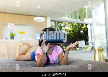 La ragazza birazziale esplora la realtà virtuale a casa Foto Stock