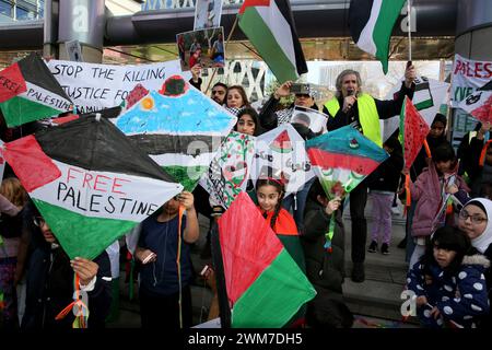 Salford, Regno Unito. 24 febbraio 2024. Centinaia di famiglie si riuniscono con i loro figli per protestare contro la BBC e la notizia "parziale" del bombardamento della Palestina. I manifestanti hanno chiesto una Palestina libera e il cessate il fuoco. I bambini hanno tenuto gli aquiloni in solidarietà con i bambini della striscia di Gaza che detengono il guiness book of record per il maggior numero di aquiloni volati contemporaneamente. I bambini hanno anche bambole bendate e fatto manifesti insieme lasciando una pila di scarpe per bambini per rappresentare i bambini uccisi a Gaza. Media City, Salford, Regno Unito. Crediti: Barbara Cook/Alamy Live News Foto Stock