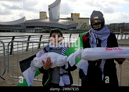 Salford, Regno Unito. 24 febbraio 2024. Centinaia di famiglie si riuniscono con i loro figli per protestare contro la BBC e la notizia "parziale" del bombardamento della Palestina. I manifestanti hanno chiesto una Palestina libera e il cessate il fuoco. I bambini hanno tenuto gli aquiloni in solidarietà con i bambini della striscia di Gaza che detengono il guiness book of record per il maggior numero di aquiloni volati contemporaneamente. I bambini hanno anche bambole bendate e fatto manifesti insieme lasciando una pila di scarpe per bambini per rappresentare i bambini uccisi a Gaza. Media City, Salford, Regno Unito. Crediti: Barbara Cook/Alamy Live News Foto Stock