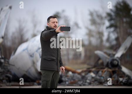 Kiev, Ucraina. 24 febbraio 2024. Il presidente ucraino Volodymyr Zelenskyy consegna video di fronte agli aerei distrutti durante l'invasione russa nel secondo anniversario dell'invasione all'aeroporto di Hostomel, 24 febbraio 2024 a Kiev, Ucraina. Credito: Pool Photo/Ufficio Stampa Presidenziale ucraino/Alamy Live News Foto Stock