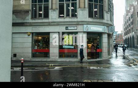 Viaggi a Londra . I pedoni e i pendolari sono stati colti da una pioggia all'angolo tra Hart Street, Londra, EC3, Gran Bretagna. 2024 Foto Stock