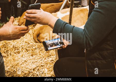 © Olivier Donnars/le Pictorium/MAXPPP - Parigi 15 24/02/2024 Olivier Donnars/le Pictorium - 24/02/2024 - Francia/Parigi 15 - Au Salon de l'agriculture, une jeune Agricultural suit sur une chaine info, la visite d'Emmanuel Macron a quelques dizaines de meters de la, accueilli sous les huees et les sifflets. - Valeurs ACtuelles Out, RUSSIA OUT, NO RUSSIA #norussia, no jdd, jdd out/24/02/2024 - Francia/Parigi 15° distretto (15° arrondissement di Parigi) - credito: MAXPPP/Alamy Live News Foto Stock