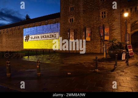 Il castello di Cardiff è illuminato dalla bandiera Ucraina e dalle parole "#Slava Ukraini" (gloria all'Ucraina! Gloria agli eroi) sabato 24 febbraio 2024, per dimostrare sostegno all'Ucraina in occasione dell'anniversario dell'invasione dell'Ucraina da parte delle forze russe.gli edifici nel Regno Unito e nel mondo si illuminano con i colori ucraini, inviando un messaggio di continuo sostegno del Regno Unito al popolo ucraino. In alcuni edifici saranno inoltre presenti le parole "Slava Ukraini” che si traduce in "Gloria all'Ucraina”. È un saluto nazionale ucraino, noto come simbolo della sovranità Ucraina e della resistenza alla Russia Foto Stock