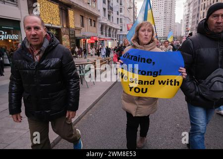 I manifestanti marciano sulla Gran via di Madrid durante una manifestazione a sostegno dell'Ucraina, per commemorare il secondo anno dell'invasione militare russa di Foto Stock