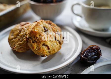 Scones fatti in casa serviti con una tazza di caffè e frutta fresca Foto Stock