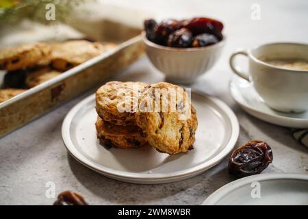 Scones fatti in casa serviti con una tazza di caffè e frutta fresca Foto Stock