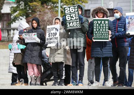 Harrisburg, Stati Uniti. 24 febbraio 2024. I manifestanti tengono i cartelli durante il rally dei lavoratori sanitari per la Palestina sui gradini del Campidoglio dello Stato della Pennsylvania ad Harrisburg, Pa. Sabato 24 febbraio 2024. La Coalizione palestinese di Harrisburg insieme ad altre organizzazioni, tra cui la Coalizione palestinese di Pittsburgh, gli studenti della Penn State per la giustizia in Palestina e la voce ebraica per la Pace di Filadelfia organizzarono la manifestazione per mostrare solidarietà agli operatori sanitari di Gaza e per chiedere un cessate il fuoco immediato. (Foto di Paul Weaver/Sipa USA) credito: SIPA USA/Alamy Live News Foto Stock