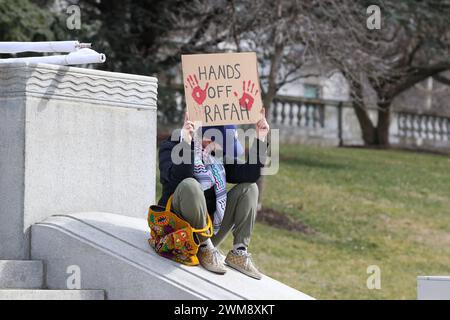 Harrisburg, Stati Uniti. 24 febbraio 2024. Un manifestante tiene un cartello durante l'Healthcare Workers for Palestine Rally sui gradini del Campidoglio dello Stato della Pennsylvania ad Harrisburg, Pa. Sabato 24 febbraio 2024. La Coalizione palestinese di Harrisburg insieme ad altre organizzazioni, tra cui la Coalizione palestinese di Pittsburgh, gli studenti della Penn State per la giustizia in Palestina e la voce ebraica per la Pace di Filadelfia organizzarono la manifestazione per mostrare solidarietà agli operatori sanitari di Gaza e per chiedere un cessate il fuoco immediato. (Foto di Paul Weaver/Sipa USA) credito: SIPA USA/Alamy Live News Foto Stock