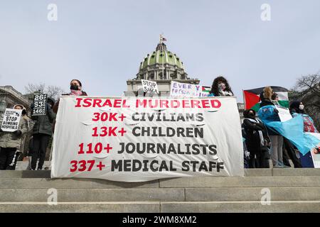 Harrisburg, Stati Uniti. 24 febbraio 2024. I manifestanti tengono i cartelli durante il rally dei lavoratori sanitari per la Palestina sui gradini del Campidoglio dello Stato della Pennsylvania ad Harrisburg, Pa. Sabato 24 febbraio 2024. La Coalizione palestinese di Harrisburg insieme ad altre organizzazioni, tra cui la Coalizione palestinese di Pittsburgh, gli studenti della Penn State per la giustizia in Palestina e la voce ebraica per la Pace di Filadelfia organizzarono la manifestazione per mostrare solidarietà agli operatori sanitari di Gaza e per chiedere un cessate il fuoco immediato. (Foto di Paul Weaver/Sipa USA) credito: SIPA USA/Alamy Live News Foto Stock