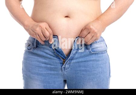 Donna grassa che cerca di indossare jeans Foto Stock