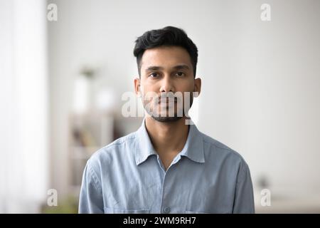 Serio ragazzo indiano in camicia blu informale in posa per la macchina fotografica Foto Stock