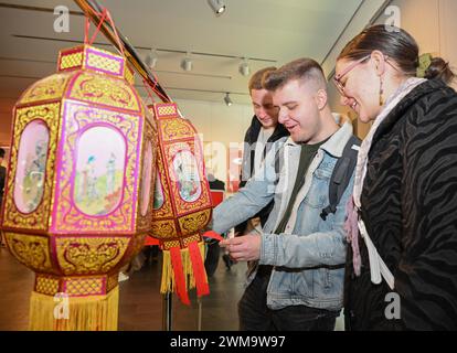 Berlino, Germania. 24 febbraio 2024. La gente legge indovinelli appesi alle lanterne durante una celebrazione del Festival delle Lanterne presso il Centro culturale Cinese di Berlino, Germania, 24 febbraio 2024. Crediti: Ren Pengfei/Xinhua/Alamy Live News Foto Stock